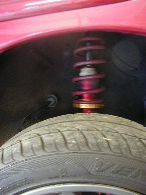 1994 Ford Probe - A close-up view of the suspension system and tire on a red vehicle.