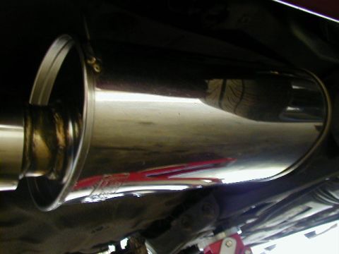 1994 Ford Probe - The underside of a vehicle shows a polished exhaust system, with a visible clamp and a red reflection on the pipe.