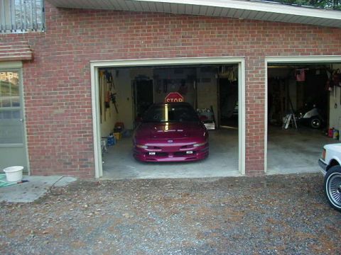 1994 Ford Probe - A purple 1994 Ford Probe sits in a garage, with another vehicle visible in the next bay.