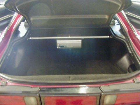 1994 Ford Probe - The trunk of a car is open, revealing a CD changer and a clean cargo area. The car's red taillights are visible below.