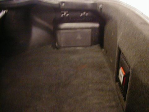 1994 Ford Probe - The interior of a car's trunk is visible, a speaker and an orange warning label on the right side.