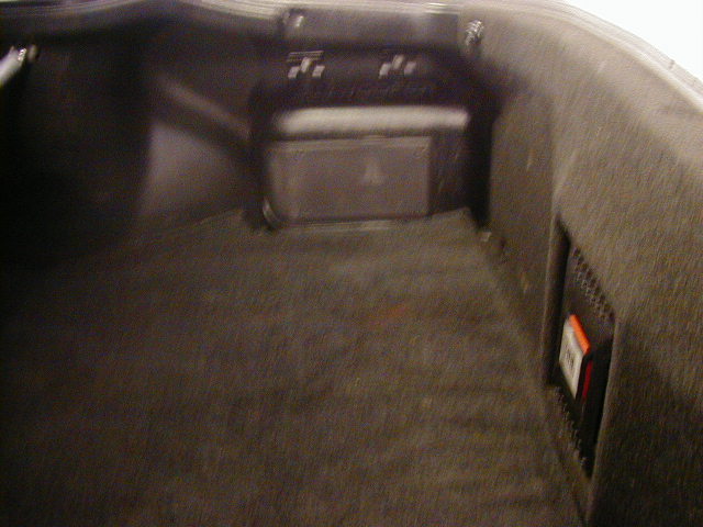Trunk interior with speaker and orange warning label