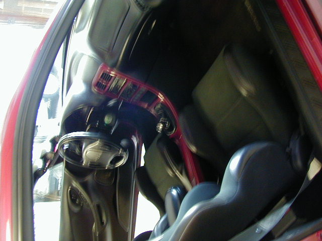 Interior view of a red car showing dark seats and part of the dashboard
