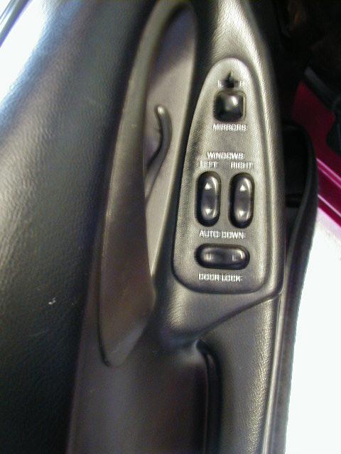 1994 Ford Probe - The interior door panel features controls for mirrors, windows, and door locks.
