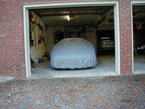 1994 Ford Probe - A car is covered in a garage, with another vehicle parked behind it.
