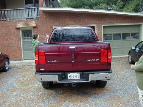 1994 Ford Probe - The rear of a red Lincoln Mark LT pickup truck is visible, with a license plate reading 'WE 4 YPI'.