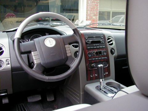 1994 Ford Probe - The interior of a Lincoln vehicle shows a wood-trimmed dashboard and center console with the brand name visible.