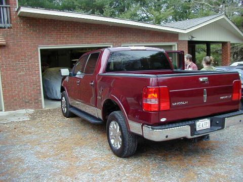 1994 Ford Probe - Red Lincoln Mark LT pickup truck parked in front of a brick garage. The truck has a chrome bumper and tailgate.