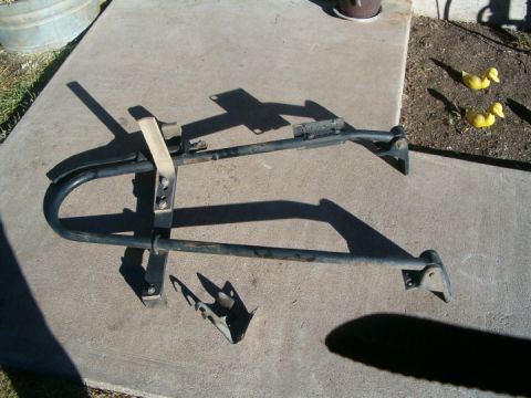 1985 Ford Bronco - This black spare tire rack, likely for an SUV, is shown disassembled on a concrete surface.