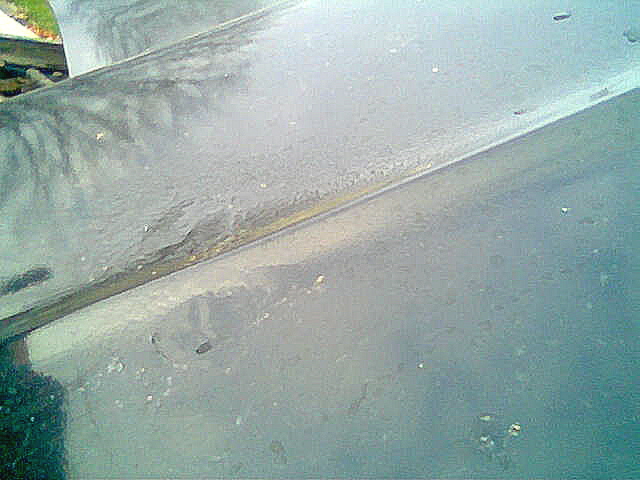Weathered truck hood with visible rust and damage