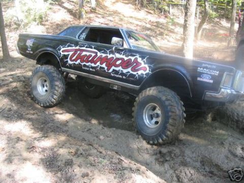 1972 Ford Ranchero - This modified pickup truck with oversized tires navigates a muddy, wooded area.