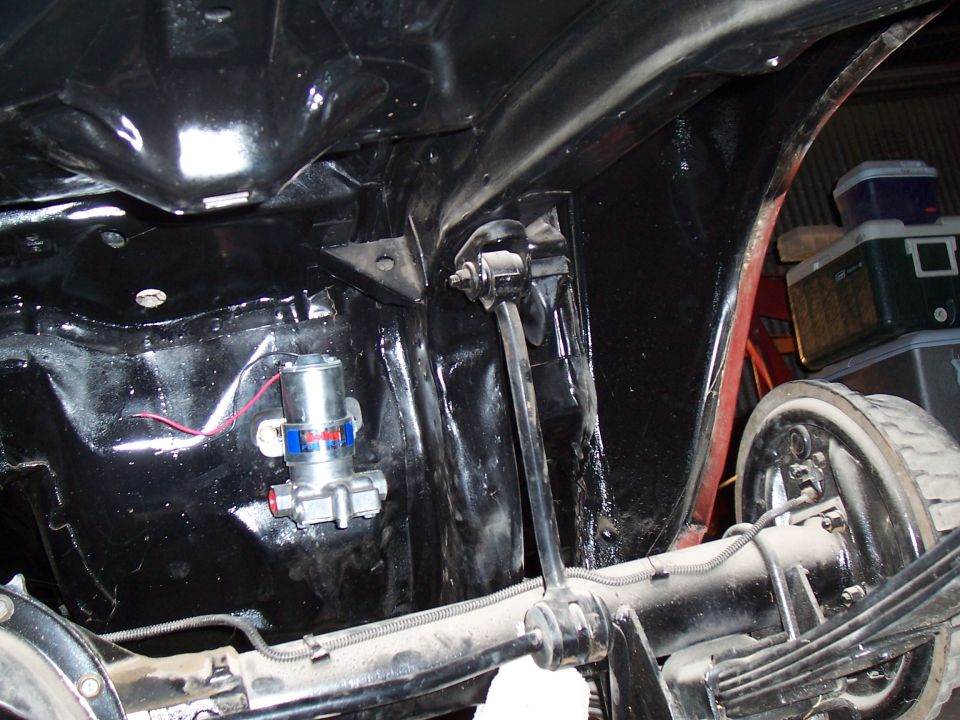 Undercarriage of a vehicle showing a fuel pump and rear axle assembly