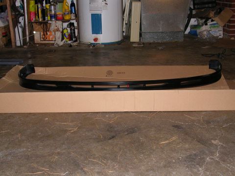 1996 Ford Probe - A black aftermarket front bumper lip is shown resting on a cardboard box in a garage.