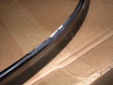 1996 Ford Probe - Damaged car trim piece showing repair work with filler applied to the surface.