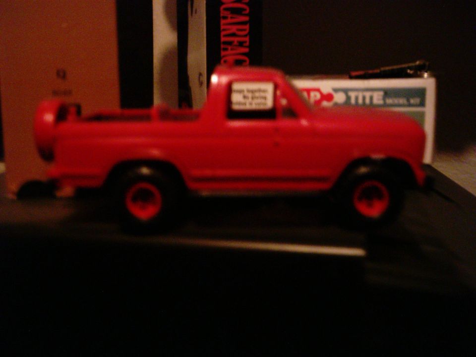 Red toy truck with a spare tire on the back, seen from the side