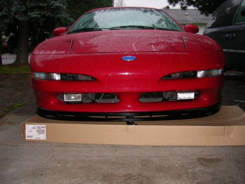1996 Ford Probe - Front view of a red 1996 Ford Probe, a black lip spoiler and a blue Ford emblem on the hood.