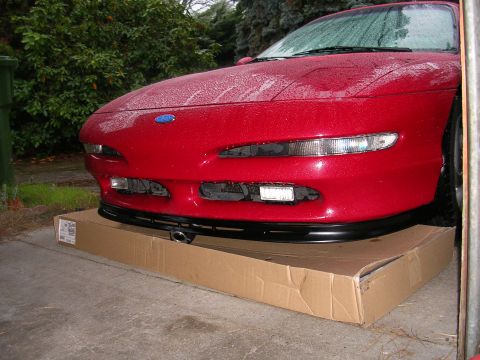 1996 Ford Probe - Front view of a red 1996 Ford Probe, a new black lip spoiler mounted on a cardboard box.