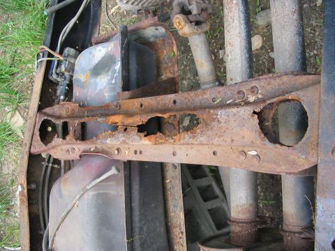 1985 Ford F-350 - The frame of this truck is severely corroded, showing significant rust damage and holes.
