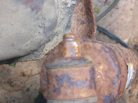 1985 Ford F-350 - Close-up view of a corroded vehicle suspension part, showing significant rust damage.