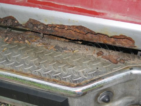 1985 Ford F-350 - Severe rust damage is visible on the vehicle's body panel and trim.