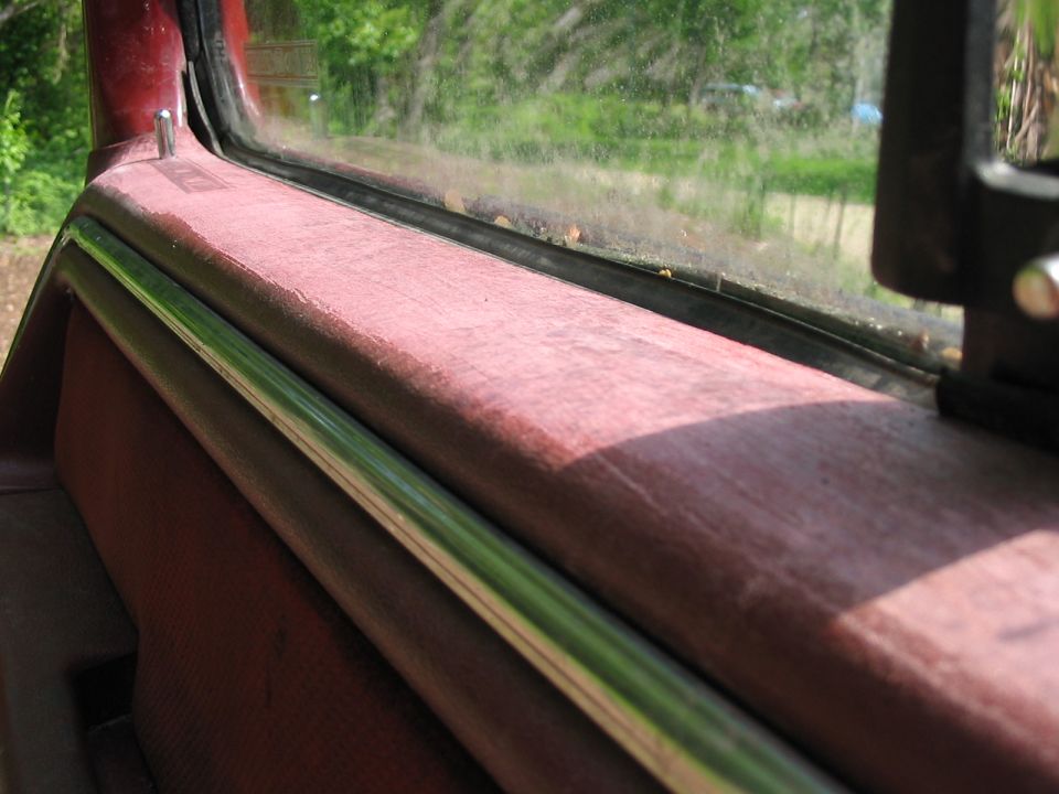 Red interior door panel with chrome trim and window frame