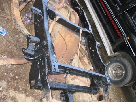 1985 Ford F-350 - Close-up of a black painted truck frame, showing leaf springs and a tire with 'Michelin' branding. The registry claims it is a 1985 Ford F-…