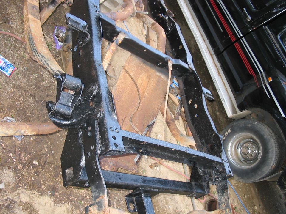 Black painted truck frame with leaf springs and tire visible. Text on tire reads 'Michelin'