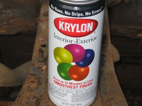 1985 Ford F-350 - A can of Krylon spray paint rests on a rusty, metallic surface, possibly part of a vehicle's undercarriage.