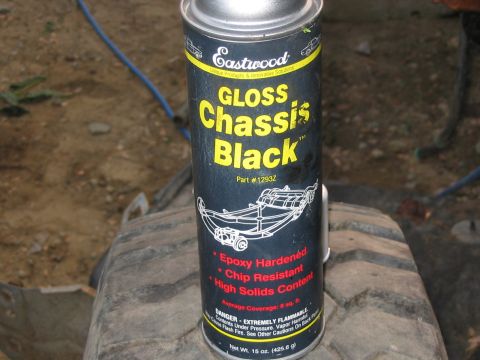 1985 Ford F-350 - A can of Eastwood Gloss Chassis Black spray paint sits on a tire, ready for automotive use.