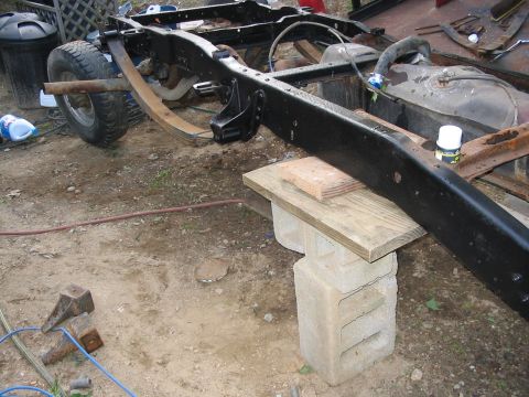 1985 Ford F-350 - Frame and fuel tank assembly of a truck, undergoing work outdoors.