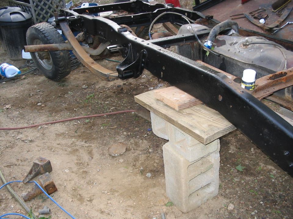 Truck frame and fuel tank assembly supported by cinder blocks and wood