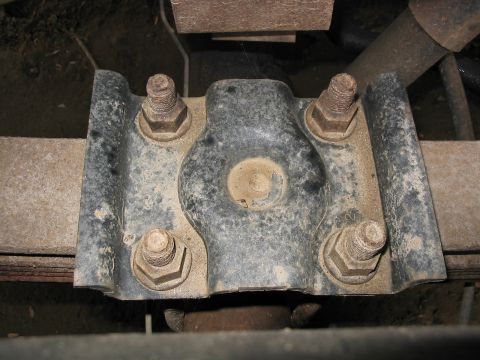 1985 Ford F-350 - Close-up view of a leaf spring U-bolt plate, showing the hardware securing it to the axle.