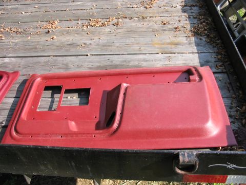 1985 Ford F-350 - A red door panel is shown from an interior perspective, resting on a wooden deck.