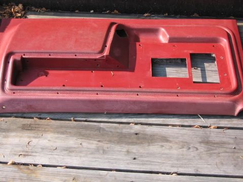 1985 Ford F-350 - A red door panel, likely from a truck, is shown from an overhead perspective on a wooden surface.
