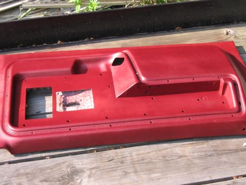 1985 Ford F-350 - Red interior door panel with cutouts for window crank and speaker, likely from a truck.