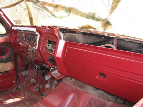 1985 Ford F-350 - The interior of a truck is shown with the dashboard removed and wiring exposed.