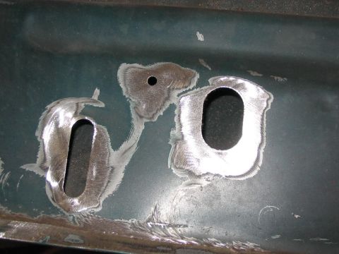 1985 Ford F-350 - Detail of a metal panel showing preparation for repair or modification, with visible cutouts and grinding.
