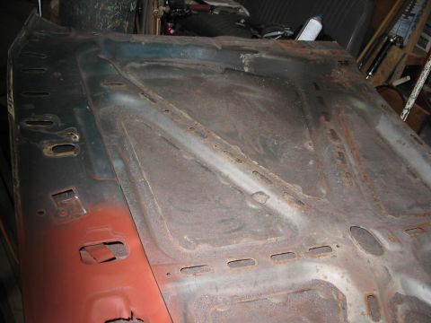 1985 Ford F-350 - Underside of a heavily rusted car hood, showing structural supports and mounting points.