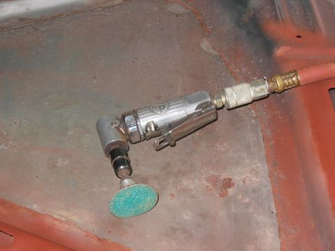 1985 Ford F-350 - An air grinder is positioned on a surface showing signs of rust and red paint.
