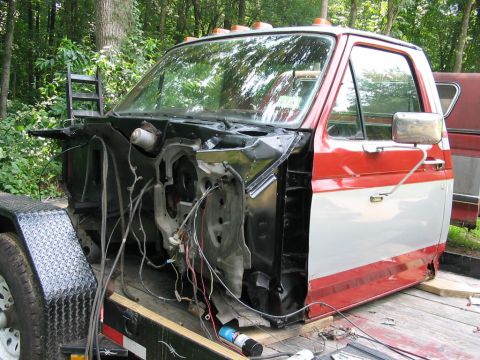1985 Ford F-350 - Cab of a Ford F-Series truck, stripped down and on a trailer, with exposed wiring.