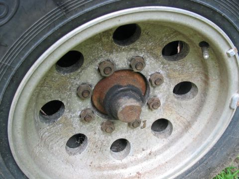 1985 Ford F-350 - This photo shows a close-up of a truck's wheel hub with lug nuts and part of the tire.