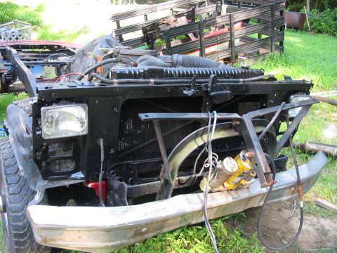 1985 Ford F-350 - Front view of a 1985 Ford F-350 showing its grille, headlights, and bumper, with engine parts visible.