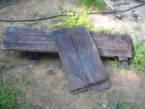 1985 Ford F-350 - Two heavily rusted metal panels are on the ground, with a Supermotors watermark visible.