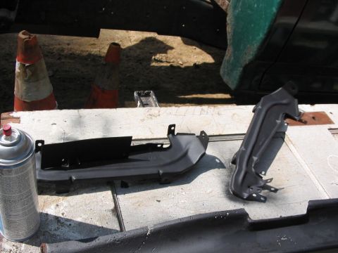 1985 Ford F-350 - Two car parts are laid out on a workbench with a can of spray paint, ready for installation.