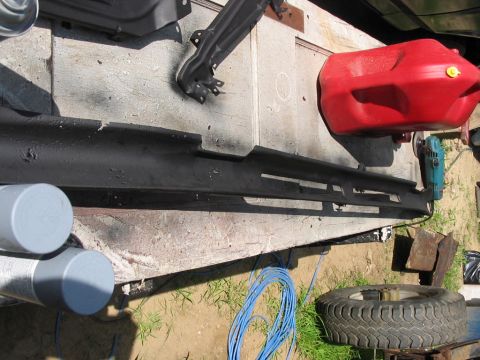 1985 Ford F-350 - A black automotive trim piece is laid out with a red gas can and tools, suggesting preparation for a vehicle repair or restoration project.