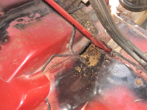 1985 Ford F-350 - The floor pan of this vehicle shows significant rust damage and exposed wood, indicating a need for repair.