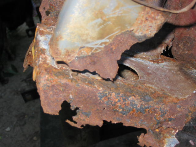 Heavily rusted metal frame with holes and peeling paint