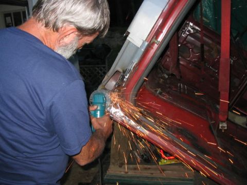 1985 Ford F-350 - Sparks fly as a man works on the interior of a red vehicle, possibly during restoration or repair.