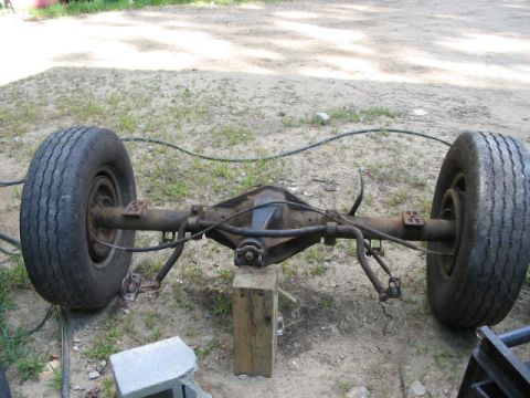 1985 Ford F-350 - Rear axle assembly with tires, supported by wooden blocks.