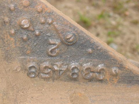 1985 Ford F-350 - A close-up view of a heavily rusted metal component with stamped identification numbers.